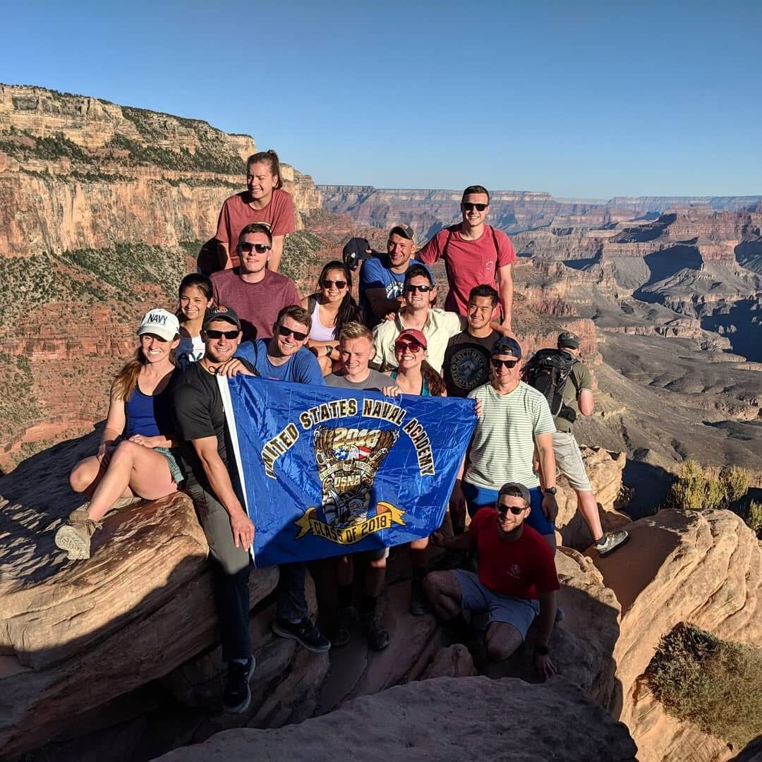 A Class Crest Flag held up at the edge of the Grand Canyon