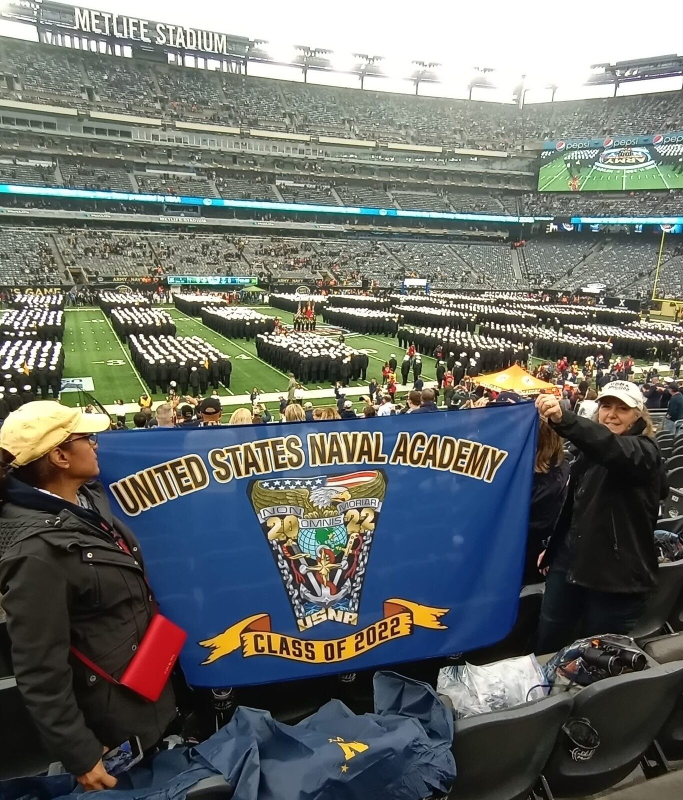 A Class Crest Flag held up in the stands at a Navy football game