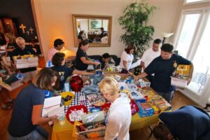 Club volunteers packing care package boxes at a table
